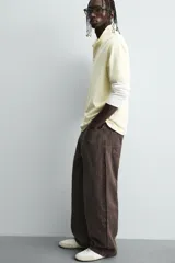 Pantalón de corte baggy fit confeccionado en tejido de algodón con textura y efecto lavado. Presenta diseño de cinco bolsillos, cierre frontal con cremallera y botón.