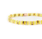 Pulsera elástica con cuentas rectangulares de color amarillo, blanco y dorado.