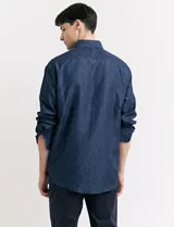 Camisa azul oscuro con estampado de motas blancas, de manga larga y corte clásico.