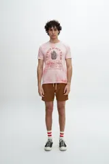 Remera manga corta color rosa con efecto tie-dye y estampa con texto y dibujo en el frente.