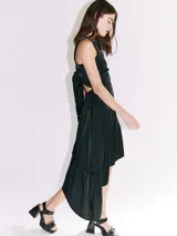 Vestido midi color salmón de tela sedosa, con cuello bote y espalda descubierta con moño.