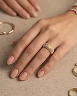 Anillo de bronce con baño de oro, diseño texturizado estilo malla y apliques florales incrustados con circonias brillantes.
