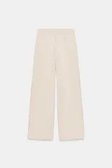 Pantalón de tiro medio confeccionado en tejido de punto elástico con pierna recta. Cuenta con cintura elástica ajustable mediante cordones y bolsillos laterales.