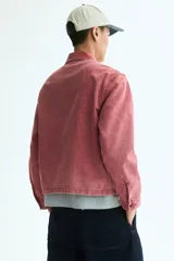 Campera de algodón color rosa con efecto acid wash, cierre frontal, cuello camisero, bolsillos delanteros ribeteados y puños con botón.