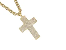 Dije dorado con forma de cruz, con incrustaciones de strass y cadena de eslabones gruesos.