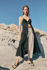 Sandalia plana tipo ojota de color negro, con tira delantera acolchada y posición para el dedo, suela baja y punta redonda.