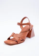 Sandalia alta de símil cuero negro con taco geométrico de 7.5 cm. Posee tiras cruzadas en el empeine con diseño pespuntado y tira ajustable con hebilla en el tobillo.