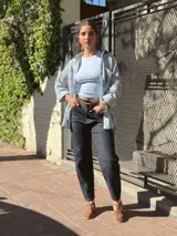 Camisa de corte oversize, con estampado a cuadros en tonos celeste, blanco y beige, cuello camisero, cierre frontal con botones y bolsillo aplicado en el pecho.