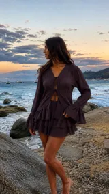 Blusa color chocolate con escote en V, cierre frontal con tiras para anudar, y mangas largas con puños acampanados y detalles de encaje.