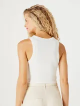 Top corto marrón de tela acanalada, con cuello redondo y sisas anchas.