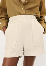 Short de corte holgado en color beige, con cintura elástica y bolsillos laterales amplios de diseño redondeado.