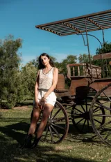 Blusa de crochet color beige con diseño calado, escote en V y terminaciones en color negro en el cuello, sisas y ruedo.
