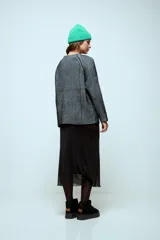 Sweater de punto con hilo de lurex brillante, color azul con rayas verticales en verde. Presenta cuello redondo, mangas largas con puños de piel sintética negra y corte holgado.