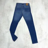 Jean azul oscuro de corte skinny con roturas en ambas rodillas.