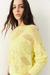 Sweater amarillo calado de manga larga con cuello redondo, puños y cintura elastizados.