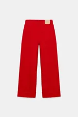 Pantalón jeans de tiro medio, corte baggy y diseño relaxed leg de color rojo con bajo acabado en vuelta. Cuenta con cinco bolsillos, trabillas para cinturón y cierre frontal con cremallera y botón.