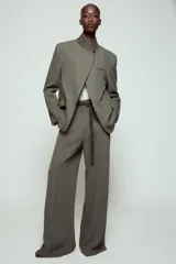 Pantalón de tiro alto con corte ancho y pernera recta. Presenta raya planchada en el delantero, bolsillos laterales y cierre frontal con cremallera y ganchos metálicos. Incluye un cinturón fino en tejido a contraste.