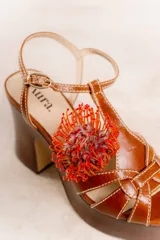 Sandalias color cuero con plataforma y taco alto forrado en madera. Diseño de tiras finas con costuras a la vista y hebilla al tobillo.