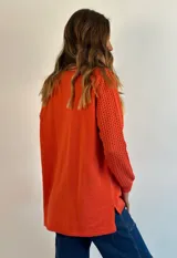 Buzo de tejido de punto ligero, color dorado con brillo sutil, escote en V y manga larga con diseño calado en los puños.