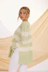 Sweater de punto color verde claro con rayas horizontales anchas color crema, de corte holgado y mangas largas.