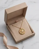 Collar de acero con baño de oro, compuesto por una cadena fina de eslabones y un dije circular tipo medalla con diseño de estrella central y circonias multicolor incrustadas.