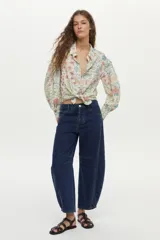 Camisa de lino y viscosa color crudo con estampado multicolor, cuello camisero, cierre frontal con botones y mangas largas abullonadas.