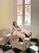 Sweater de punto con diseño geométrico en tonos celeste, marrón y beige.