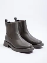 Bota tipo Chelsea de símil cuero color suela, con plataforma oscura, punta cuadrada y paneles elásticos laterales.