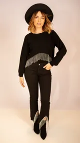 Pantalón de jean negro con corte recto, tiro medio y terminaciones con flecos de strass.