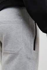 Pantalón jogging de corte slim, con puños elastizados, cintura con cordón ajustable, cierres laterales engomados y bolsillo tipo parche lateral.