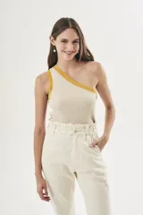 Top tejido color crema con rayas verticales y ribete amarillo en el escote asimétrico.