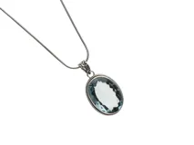 Dije de plata 925 con forma ovalada y piedra aguamarina facetada.