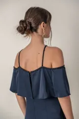 Vestido largo azul marino de crepe de seda, con breteles finos y escote off-shoulder con volado. Presenta bordes bordados en el escote y breteles.