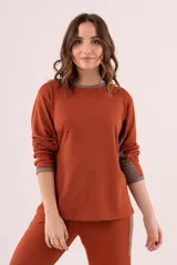 Conjunto de pijama color ladrillo, de lanilla, con cuello redondo y puños en color gris.