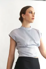 Top celeste de seda con cuello mao y espalda descubierta.