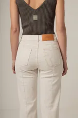 Jean de denim negro, tiro alto y corte recto, con costuras verticales decorativas en el frente.