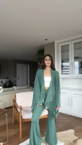 Pantalón largo de tejido de punto color verde esmeralda con lurex, corte ajustado y acampanado.