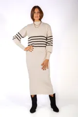 Conjunto de dos piezas compuesto por un sweater de cuello alto con rayas horizontales negras y un vestido largo de corte recto en tejido de punto acanalado.