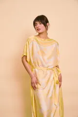 Vestido midi amarillo y blanco con estampado de paisajes y detalles de rayas en el cuello y el dobladillo, de corte holgado, mangas cortas y lazo ajustable en la cintura.