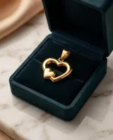 Dije de acero con baño dorado, compuesto por dos corazones concéntricos de diseño minimalista.