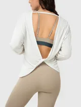 Polera de manga larga con espalda abierta y detalle de nudo en la parte inferior. Confeccionada en modal, presenta un diseño ligero y fluido ideal para actividades deportivas.