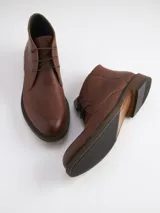 Botas de cuero marrón con cordones, caña baja y suela de goma.