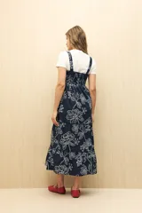 Vestido midi blanco con bordado floral calado, corte evasé y breteles finos.