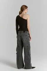 Top asimétrico de morley color negro, con una sola manga larga con tajo en el puño y largo hasta la cadera.