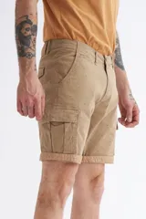 Bermuda cargo color beige con pequeños lunares verdes, bolsillos laterales con solapa y ruedo con dobladillo.