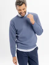Buzo de tejido con textura tipo panal, color azul, con cuello redondo y puños y ruedo acanalados.