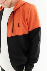 Campera de nylon impermeable con capucha, color naranja en la parte superior y negro en la parte inferior.