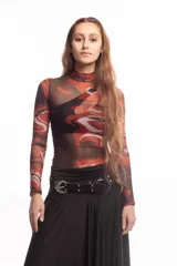 Top de cuello alto y manga larga confeccionado en tejido de malla semitransparente con estampado artístico abstracto en tonos rojizos, negros y blancos.