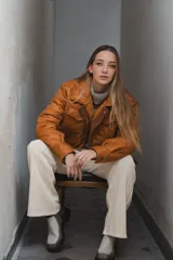 Campera acolchada color ladrillo con cuello marrón de pana, cierre frontal con botones a presión y bolsillos laterales.