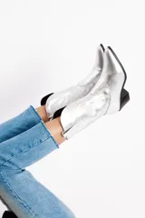 Botas tejanas de cuero plateado con taco bajo y cierre lateral.